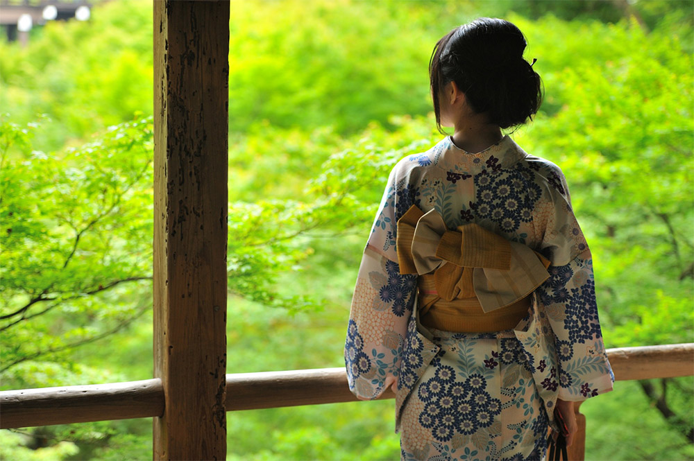 Back of a woman wearing a kimono with the obi sash tied in the tateya musubi style of kimono